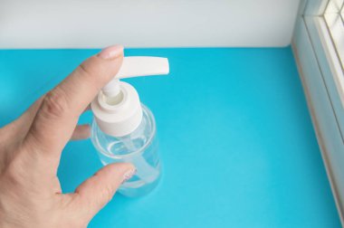 Kadınlar ellerini bir şişe dezenfektanla yıkıyor. Koronavirüs hastalığının antiseptik önleyicisi..