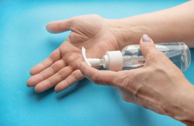 Kadınlar ellerini bir şişe dezenfektanla yıkıyor. Koronavirüs hastalığının antiseptik önleyicisi.