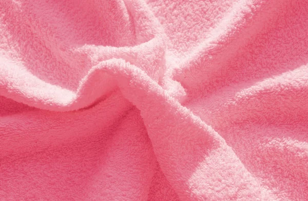 Pembe tüylü Terry havlusu, yumuşak, tüylü bir kumaşın dokusunun basit bir örneği, kıvrımların arka planı..