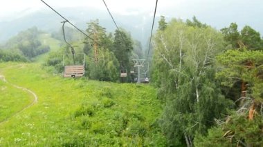 Resimli manzara, dağın tepesinden teleferikle, dağın eteğindeki şehirle, HD videosuyla açılır.