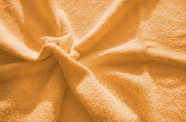 オレンジふわふわテリータオル 柔らかくてフリース生地の質感の簡単な例 折り目の背景 — ストック写真