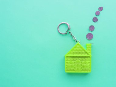 Ev şeklinde anahtarlığı olan bir ipotek anlaşması konsepti, emlak sigortası ve uzay kopyası..