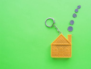 Ev şeklinde anahtarlığı olan bir ipotek anlaşması konsepti, emlak sigortası ve uzay kopyası..