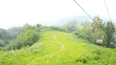 Resimli manzara, dağın tepesinden teleferikle, dağın eteğindeki şehirle, HD videosuyla açılır.