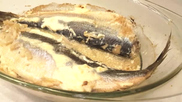全体のロースト魚を準備 ニシン ソースをオーブンで焼き 透明ガラス耐熱トレイで魚を調理 4Kビデオ — ストック動画