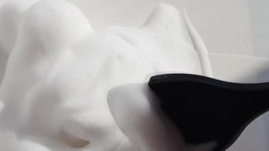 Berber saç boyasını fırçayla karıştırır ve hazırlar, saç bakımı için beyaz köpük, kaplıca salonu