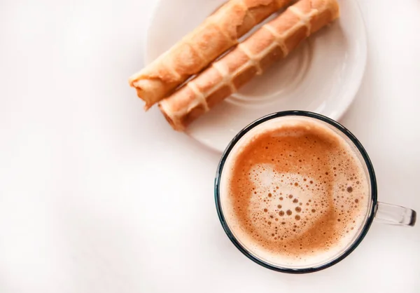 Bicchiere blu chiaro con caffè espresso caldo schiumoso e cialde croccanti, vista dall'alto, deliziosa colazione — Foto Stock