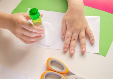 Üçüncü adım. Çocuk yapıştırıcı kullanıyor. DIY ve çocukların yaratıcılığı kavramı. Adım adım talimatlar: Kağıttan Panda uygulaması nasıl yapılır. Karantina sırasında bir çocukla yaratıcı faaliyetler.