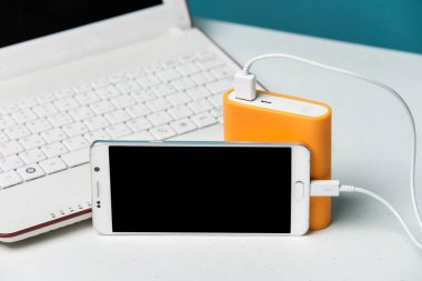 arka planda Modern dizüstü taşınabilir harici pil ile akıllı telefon şarj