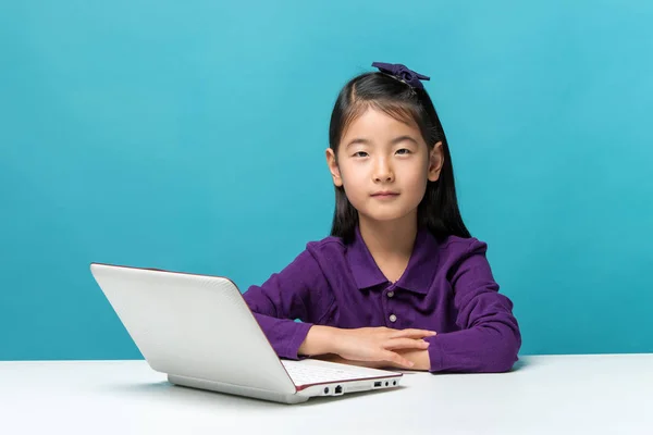 Menina asiática bonito que gosta do computador portátil no fundo azul — Fotografia de Stock