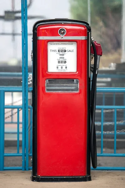 Alte Benzinpumpe in schwarz und leuchtend rot in der Umgebung lackiert — Stockfoto