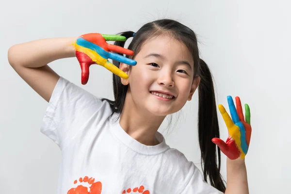 Pequeña chica asiática con las manos pintadas en pinturas de colores — Foto de Stock