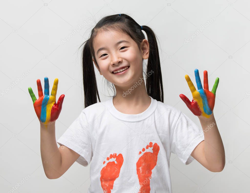 Little Asian girl with hands painted in colorful paints