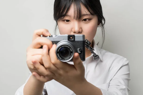 Mão feminina segurando câmera moderna (câmera sem espelho ). — Fotografia de Stock