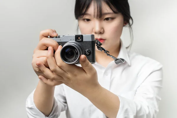 Mão feminina segurando câmera moderna (câmera sem espelho ). — Fotografia de Stock