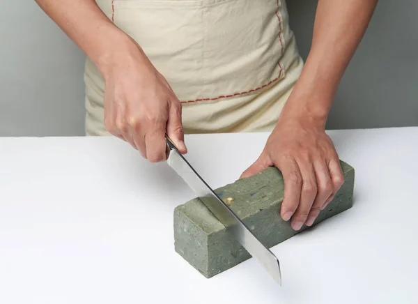 man cutting a handmade soap with a knife.