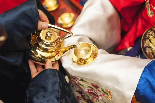 Traditional wedding in Korea. The hand that the groom gives the bride to follow the Korean traditional liquor