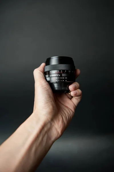 Mão Homem Segurando Uma Lente Câmera Fundo Preto — Fotografia de Stock