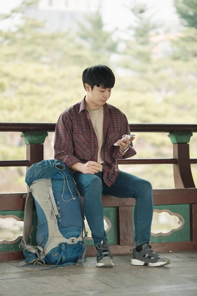 Молодой Человек Путешествует Рюкзаком Корейском Традиционном Доме Используйте Свой Смартфон — стоковое фото