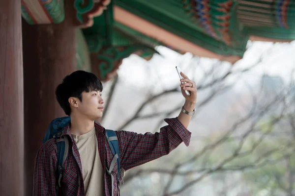Молодой Человек Путешествует Рюкзаком Корейском Традиционном Доме Фотографирую Своего Смартфона — стоковое фото