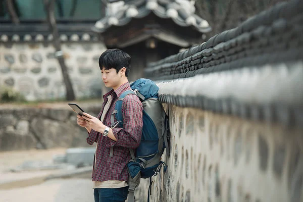 Ένας Νεαρός Άνδρας Backpacking Στην Κορέα Χρησιμοποιώντας Έναν Υπολογιστή Tablet — Φωτογραφία Αρχείου