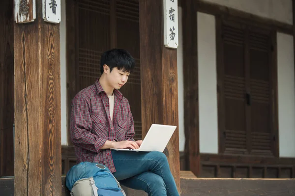 Joven Mochilero Corea Usando Portátil Sentado Una Casa Tradicional Coreana Fotos de stock libres de derechos