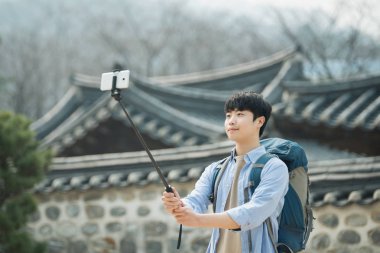 Kore'ye seyahat eden genç bir adam onun smartphone kullanarak fotoğraf çekme.