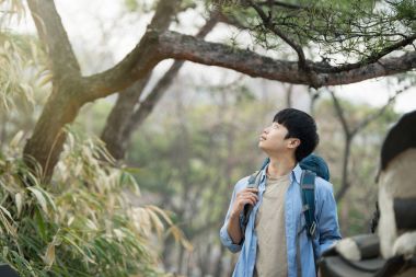 Kore geleneksel evde bir sırt çantasıyla yolculuk yapan bir genç erkek.