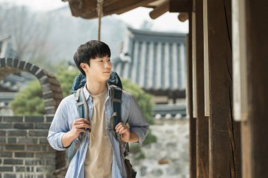 Kore geleneksel hou bir sırt çantasıyla yolculuk yapan bir genç erkek