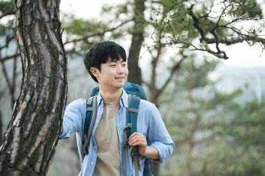 Kore geleneksel evde bir sırt çantasıyla yolculuk yapan genç erkek.