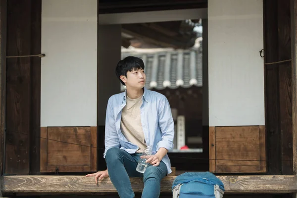 一个在韩国旅行的年轻人正在用水壶休息 — 图库照片