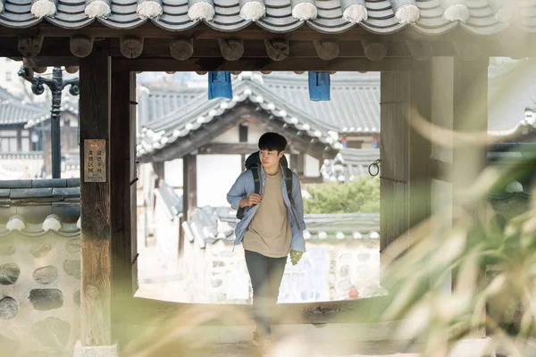 一个年轻男子在韩国传统的房子里做背包旅行 — 图库照片