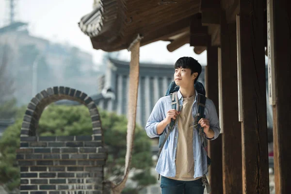 一位年轻男子在韩国传统的侯做背包旅行 — 图库照片