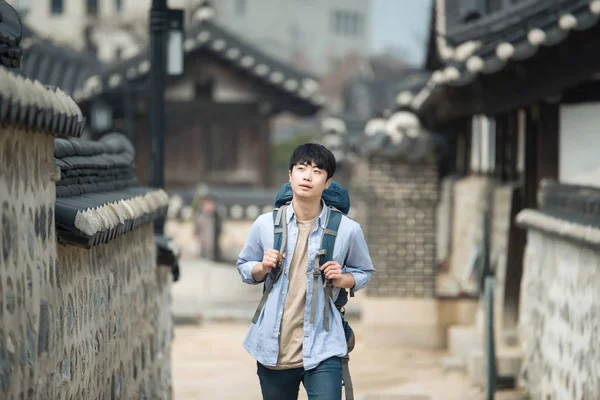 Νεαρός άνδρας κάνει ένα backpacking ταξίδι σε μια κορεατική παραδοσιακή κατοικία. — Φωτογραφία Αρχείου