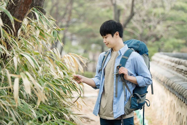 Fiatal férfi csinál egy koreai hagyományos házban hátizsákkal. — Stock Fotó