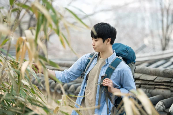 韓国の伝統的な家でのバックパッカー旅行をしている若い男. — ストック写真