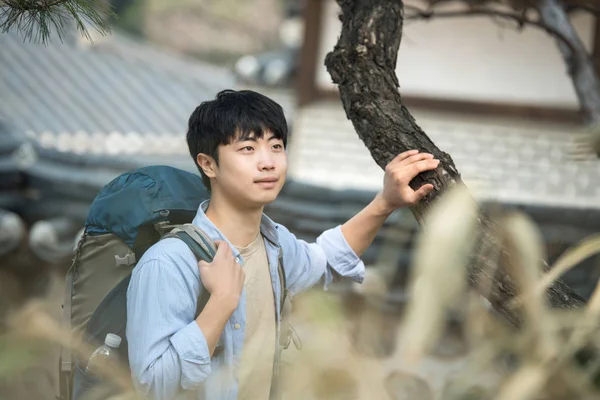 Νεαρός άνδρας κάνει ένα backpacking ταξίδι σε μια κορεατική παραδοσιακή κατοικία. — Φωτογραφία Αρχείου