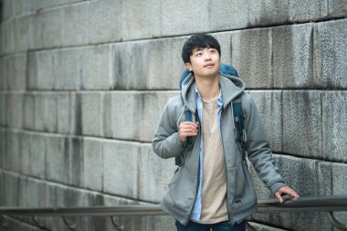 Kore geleneksel evde bir sırt çantasıyla yolculuk yapan bir genç erkek.