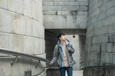 Kore geleneksel evde bir sırt çantasıyla yolculuk yapan bir genç erkek.