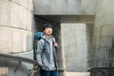 Kore geleneksel evde bir sırt çantasıyla yolculuk yapan bir genç erkek.