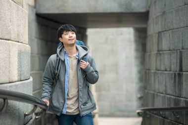 Kore geleneksel evde bir sırt çantasıyla yolculuk yapan bir genç erkek.