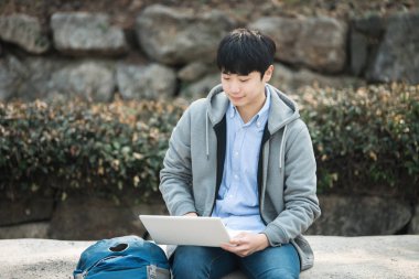 Dizüstü bilgisayar kullanarak backpacking Asyalı adam