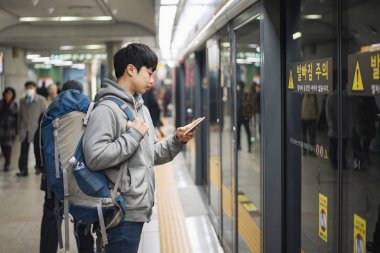 Genç adam Kore, metro için bekleyen erkek seyahat