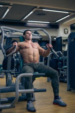 vücut geliştirmeci simülatörü üzerinde çalışmak zor. eğlenceli spor salonunda. sağlıklı yaşam tarzı.