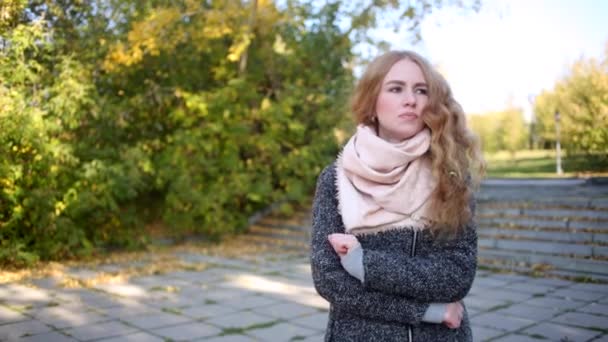 Pelirroja chica está esperando en el parque — Vídeos de Stock