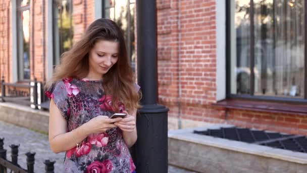 Roodharige meisje loopt op straat — Stockvideo