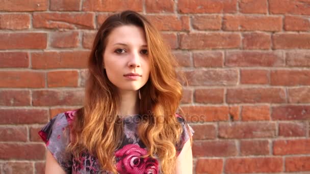 Roodharige mooie meisje en bakstenen muur — Stockvideo