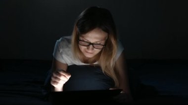 Makara kızla bir yatak odasında yatıyor ve tablet kullanır