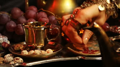 Bardağa eller ile oryantal takı çay yapma. Geleneksel Fas tatlılar. Safran Masala süt çay fincan