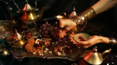 Bardağa eller ile oryantal takı çay yapma. Geleneksel Fas tatlılar. Safran Masala süt çay fincan